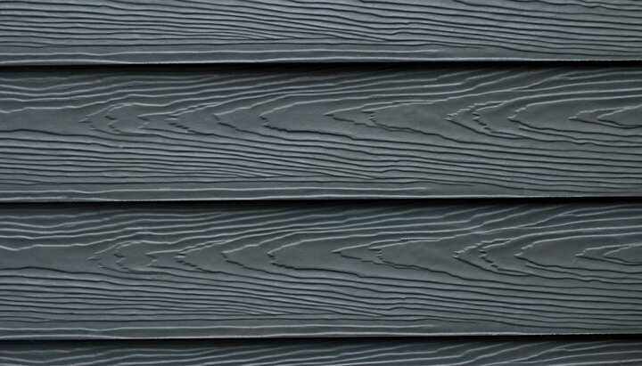 Beautiful grey fiber cement siding with natural looking wood grain installed on an older home.